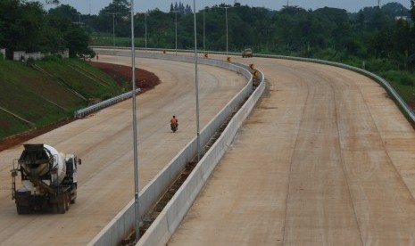 Pekerja dengan mengendarai kendaraan melintas di proyek pembangunan ruas tol Cinere - Cengkareng atau Tol Jakarta Outer Ring Road II (JORR II) sesi ruas Serpong - Kunciran di Serpong, Tangerang Selatan, Banten, Selasa (27/11/2018).