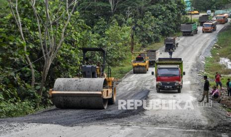 Pekerja dibantu alat berat memperbaiki Jalan Semboja-Sepaku yang sempat rusak di Kecamatan Samboja, Kutai Kartanegara, Kalimantan Timur, Ahad (13/3/2022). Jalan tersebut merupakan akses menuju Ibu Kota Negara (IKN) Nusantara dari Kota Balikpapan, Kalimantan Timur. 