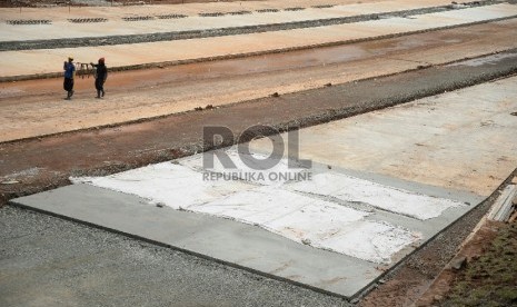 Pekerja dibantu alat berat menyelesaikan pembangunan proyek Tol Cijago, di Jalan Juanda, Depok, Jawa Barat, Senin(9/3). 