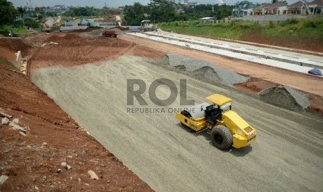 Pekerja dibantu alat berat menyelesaikan pembangunan proyek Tol Cijago, di Jalan Juanda, Depok, Jawa Barat, Senin(9/3). 