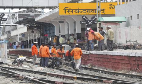 Pekerja kereta api mengeluarkan sepeda motor yang dibakar oleh pengunjuk rasa dari rel kereta api di stasiun kereta api Secundrabad di Hyderabad, India, Jumat, 17 Juni 2022. Ratusan pemuda yang marah melampiaskan kemarahan mereka dengan membakar gerbong kereta, merusak properti kereta api dan memblokir rel dan jalan raya dengan batu-batu besar sebagai serangan balasan untuk hari kedua berturut-turut pada hari Jumat terhadap skema rekrutmen pemerintah jangka pendek yang baru untuk militer. Hampir 500 pengunjuk rasa jauh melebihi jumlah polisi saat mereka mengamuk selama lebih dari satu jam di stasiun kereta api Secundrabad di India selatan.