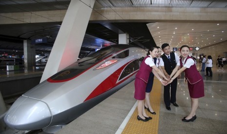 Pekerja kereta berpose di dekat CR400AF, kereta terbaru Cina dengan kecepatan 400 km/jam.