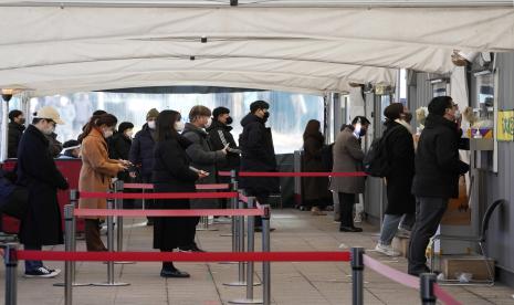 Pekerja medial di bilik mengambil sampel hidung dari orang-orang di tempat pengujian darurat di Seoul, Korea Selatan, Jumat, 28 Januari 2022. Korsel Pecah Rekor, Kasus Covid-19 Tembus Satu Juta