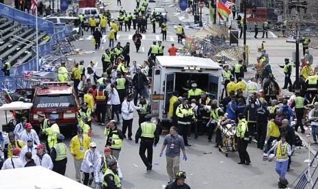 Pekerja medis mebantu para korban terluka akibat ledakan bom di garis finis pada perlombaan Maraton Boston 2013 pada 15 April 2013