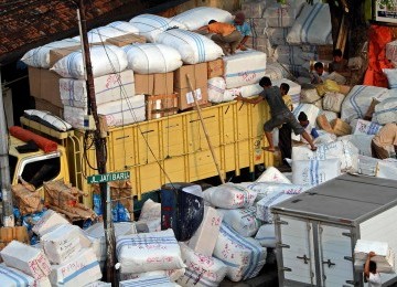 Pekerja melakukan bongkar muat barang di tempat jasa pengiriman barang di kawasan Tanah Abang, Jakarta, Senin (25/7). Jelang bulan Ramadhan, aktivitas pengiriman barang mulai meningkat.