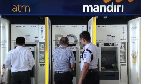  Pekerja melakukan fasilitas pelayanan di ATM Bank Mandiri, Jakarta, Senin (19/10).