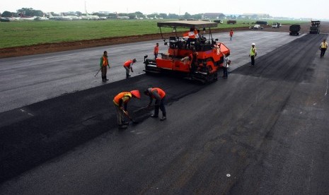 Pekerja melakukan pengaspalan ulang landasan pacu