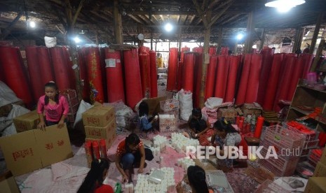 Pekerja melakukan pengepakan pada lilin yang telah diproduksi untuk perayaan Imlek di Teluk Naga, Tangerang, Banten, Kamis (28/1).