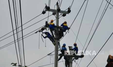 Pekerja melakukan pengerjaan perawatan dan peninggian jaringan kabel listrik PLN (ilustrasi)