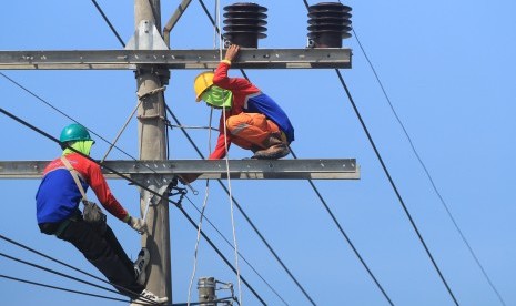 Pekerja melakukan perawatan jaringan listrik di jalur Pantura Lohbener, Indramayu, Jawa Barat, Selasa (28/5/2019).