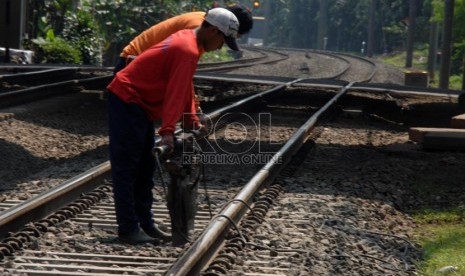  Pekerja melakukan perawatan rel kereta api yang menghubungkan Jakarta-Depok di jalur Lenteng Agung, Jakarta Selatan, Jumat (19/7).    (Republika/Rakhmawaty La'lang)