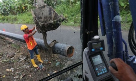 Pekerja melakukan proses penggalian, penurunan dan penimbunan pipa proyek Pertamina Gas, di kawasan Tol Belmera, di Medan, Sumatera Utara, Jumat (6/11). 