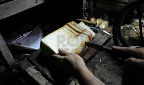 Pekerja melakukan proses tahap akhir pembuatan roti tawar usaha kecil menengah di Jakarta, Rabu (16/4).