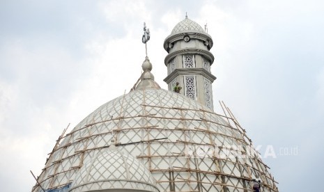 Pekerja melakukan renovasi kubah di Masjid Jami ALWiqoyah, Jakarta, Ahad (8/10). 