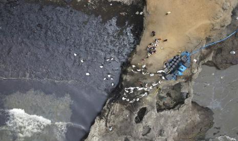 Pekerja melanjutkan pembersihan tumpahan minyak di Cavero Beach, di distrik Ventanilla, Peru, 22 Januari 2022.