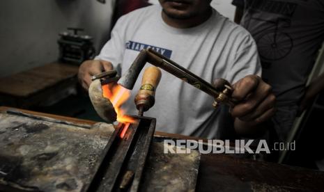 Pekerja melebur emas untuk dijadikan perhiasan di Cikini Gold Center, Jakarta, Jumat (24/7). Emas berjangka turun tajam pada akhir perdagangan Rabu (23/9), memperpanjang kerugiannya untuk hari ketiga berturut-turut. 