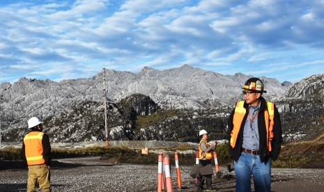  Pekerja melintas berlatarbelakang pegunungan Jayawijaya di kawasan Grasberg Mine milik PT. Freeport Indonesia (PTFI ) di Tembagapura, Mimika, Timika, Papua, Minggu (15/2).