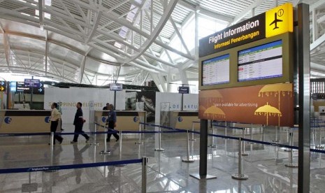 Pekerja melintas dan suasana sepi ketika penutupan sementara Bandara Internasional Ngurah Rai, Denpasar, Bali, Selasa (8/10).  (Antara/M Agung Rajasa)