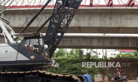 Pekerja melintas di bawah konstruksi jalur rel dwi ganda double-double track di Jakarta Timur, Jumat (2/2).