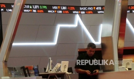 Pekerja melintas di dekat monitoir perkembangan Indeks Harga Saham Gabungan (IHSG) di Bursa Efek Jakarta (BEJ) Jakarta. 