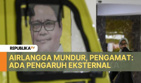 Pekerja melintas di dekat poster Airlangga Hartarto di DPP Partai Golkar, Jakarta, Ahad (11/8/2024). Airlangga Hartarto mengundurkan diri dari jabatan Ketua Umum Partai Golkar.