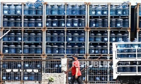 Pekerja melintas di depan depo pengisian air minum dalam kemasan Daan Mogot, Jakarta, Sabtu (7/8/2021). Direktur Wahana Lingkungan Hidup Indonesia (Walhi) DKI Jakarta, Suci F Tanjung, menyoroti tingginya konsumsi air minum dalam kemasan yang kian mengkhawatirkan. 