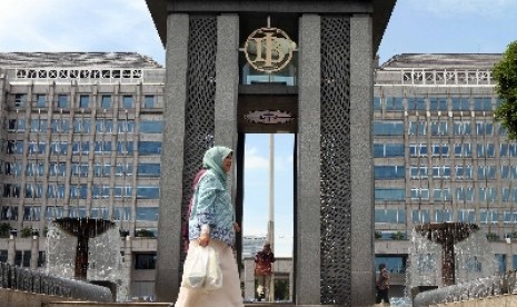 Pekerja melintas di depan logo Bank Indonesia di Jakarta, Ahad (27/4).