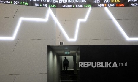 Pekerja melintas didekat layar pergerakan Indeks Harga Saham Gabungan (IHSG) di Gedung Bursa Efek Indonesia (BEI), Jakarta, Selasa (4/4).