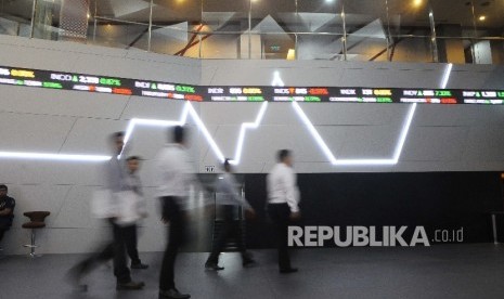 Pekerja melintas didekat layar pergerakan Indeks Harga Saham Gabungan (IHSG) di Gedung Bursa Efek Indonesia (BEI), Jakarta. ilustrasi