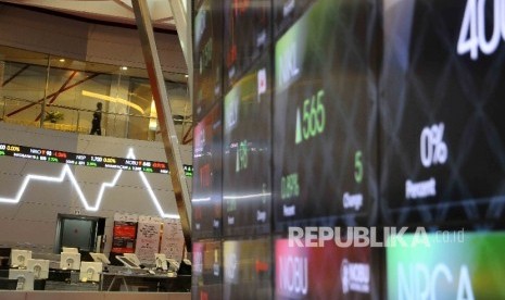 Pekerja melintas disamping layar pergerakan Indeks Harga Saham Gabungan (IHSG) di Gedung Bursa Efek Indonesia (BEI), Jakarta.