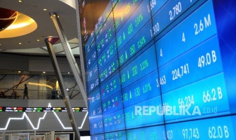 Pekerja melintas disamping layar pergerakan Indeks Harga Saham Gabungan (IHSG) di Gedung Bursa Efek Indonesia (BEI) Jakarta. 