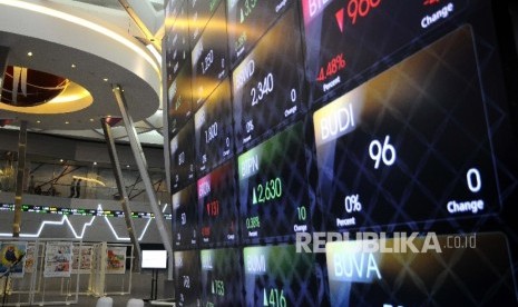 Pekerja melintas disamping layar pergerakan Indeks Harga Saham Gabungan (IHSG), Gedung Bursa Efek Indonesia (BEI) Jakarta. ilustrasi