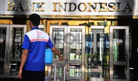 Pekerja melintas pada kantor Bank Indonesia, Jakarta, Jumat (18/12).