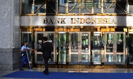 Pekerja melintas pada kantor Bank Indonesia, Jakarta, Jumat (18/12).