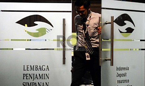  Pekerja melintas saat melakukan aktifitas di kantor Lembaga Penjamin Simpanan (LPS), Jakarta, Kamis (6/8).