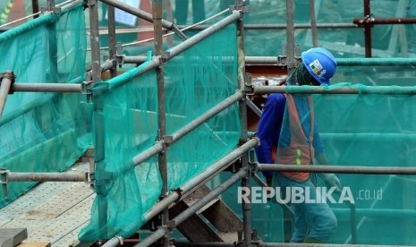  Pekerja melintas saat sedang menyelesaikan pembangunan infrastruktur di Jakarta, Selasa (7\2).