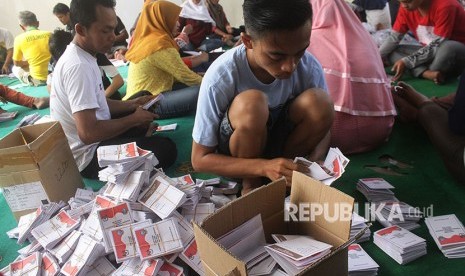 Pekerja melipat dan menyortir surat suara Pilgub Jatim di KPU Ngawi, Jawa Timur, Rabu (23/5). 