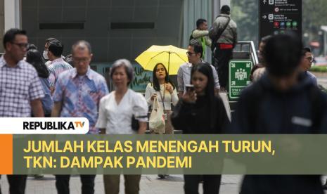 Pekerja memakai payung saat melintasi Jalan Jenderal Sudirman, Jakarta, Kamis (2/5/2024).