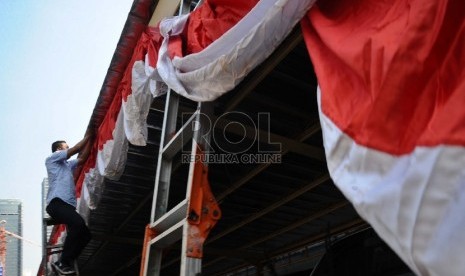  Pekerja memasang atribut merah putih di kawasan perkantoran Thamrin, Jakarta, Jumat (7/8). 