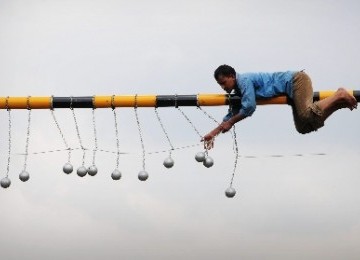 Pekerja memasang bola-bola besi penghalang penumpang atap gerbong kereta api di jalur kereta api Tambun-Bekasi, Bekasi, Jawa Barat, Selasa (17/1). 