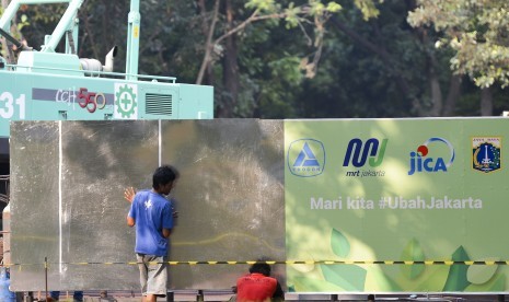 Pekerja memasang dinding pembatas pembangunan proyek Moda Raya Terpadu (MRT) Fase II di kawasan Monumen Nasional (Monas), Jakarta, Kamis (27/6/2019).