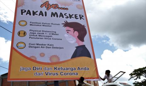 Pekerja memasang imbauan menggunakan masker di Syech Yusuf, Kendari, Sulawesi Tenggara, Selasa (7/4/2020). Pemerintah kota Kendari bekerja sama dengan pemilik billboard serta media advertising memasang imbauan kepada seluruh masyarakat menggunakan masker untuk mengurangi risiko penyebaran wabah virus COVID-19 serta tetap melakukan jaga jarak fisik.