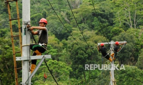 Pekerja memasang instalasi listrik di desa Kamiri, Barru, Sulawesi Selatan, Senin (15/1). 