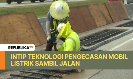 Pekerja memasang kabel pengecasan mobil listrik di jalan raya di wilayah Indiana, Amerika Serikat.