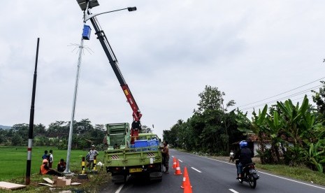 Pekerja memasang lampu penerangan jalan di jalur selatan kawasan Dayeuhluhur, Cilacap, Jawa Tengah. ilustrasi