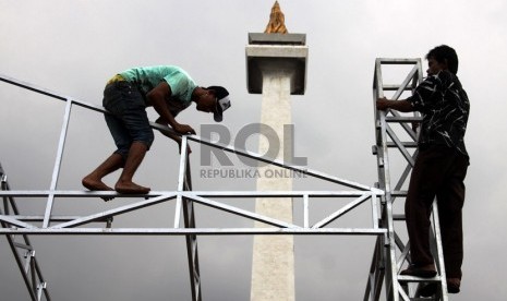  Pekerja memasang panggung dalam rangka persiapan perayaan HUT ke-486 Jakarta di Monumen Nasional, Jakarta, Kamis (20/6).    (Republika/ Yasin Habibi)