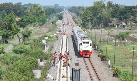 Pekerja memasang rel Kereta Api (KA) yang merupakan bagian dari pembangunan jalur ganda KA lintas selatan di Kota Madiun, Jawa Timur, Rabu (28/11/2018).