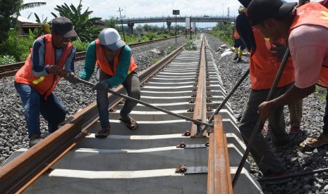 Pekerja memasang rel Kereta Api (KA) yang merupakan bagian dari pembangunan jalur ganda KA lintas selatan di Kota Madiun, Jawa Timur, Rabu (28/11/2018).