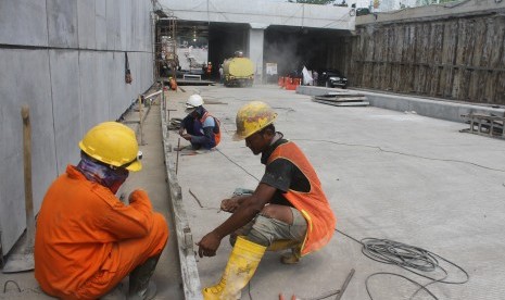 Pekerja memasang saluran air saat membangun jalan bawah tanah atau underpass (ilustrasi)