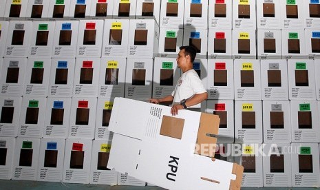 Pekerja membawa kotak suara yang akan dirakit di gudang logistik KPU Depok, Jawa Barat, Rabu (13/2/19). 